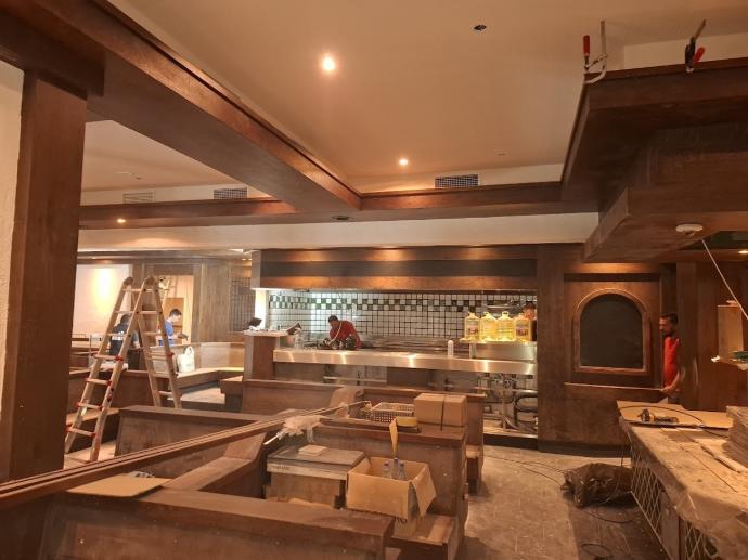 Instalaciones en el interior del nuevo restaurante BLOCK HOUSE en Roquetas de Mar, Almería, durante la fase de reforma con estructura de madera y mostrador metálico.